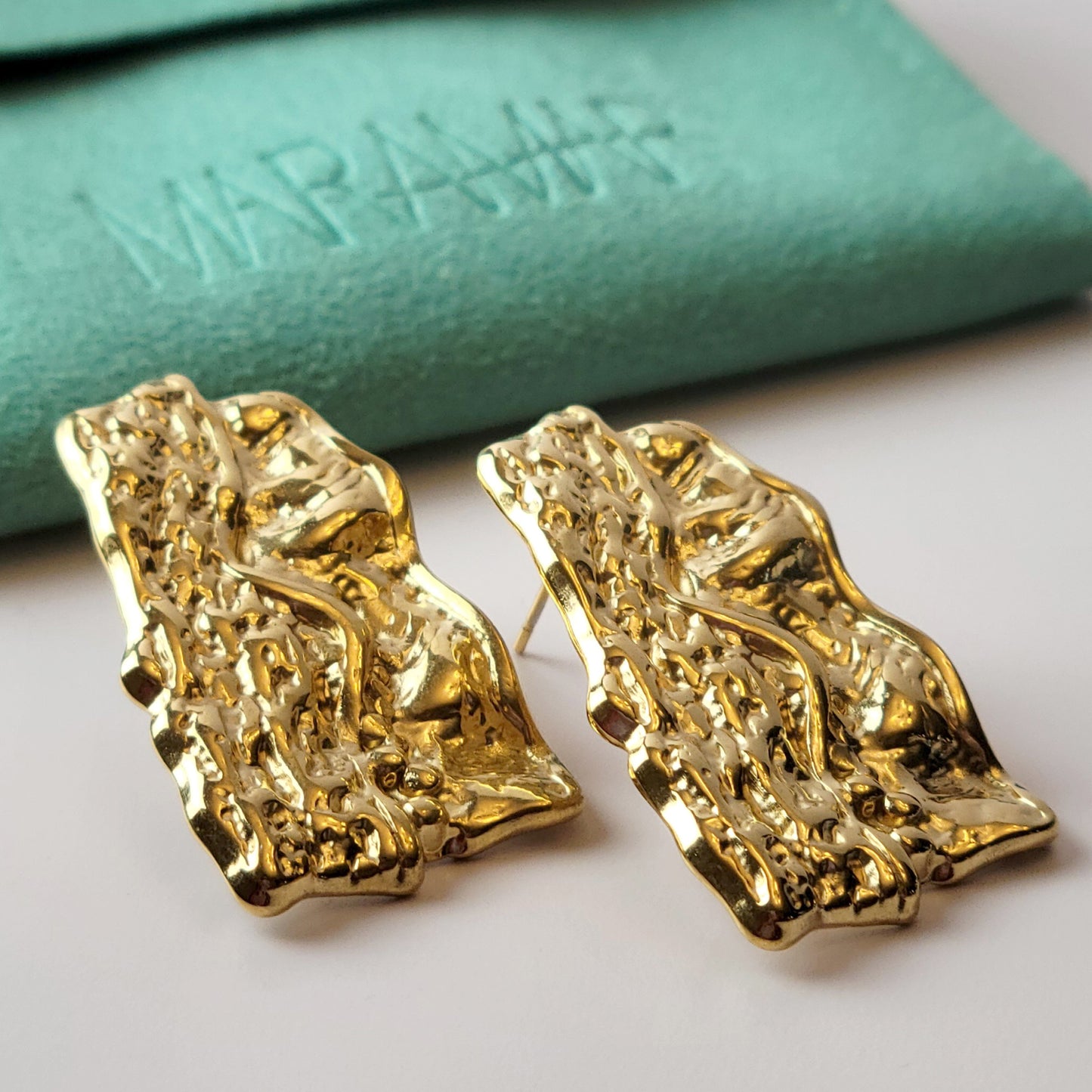 These Gold Chunky Rectangular Dangle Earrings are expertly crafted with hypoallergenic stainless steel to provide a sustainable, low maintenance option for your jewelry collection. Their tarnish-proof design ensures long-lasting wear, while their lightweight construction offers comfort for all-day wear. Elevate your style with these elegant and versatile earrings.