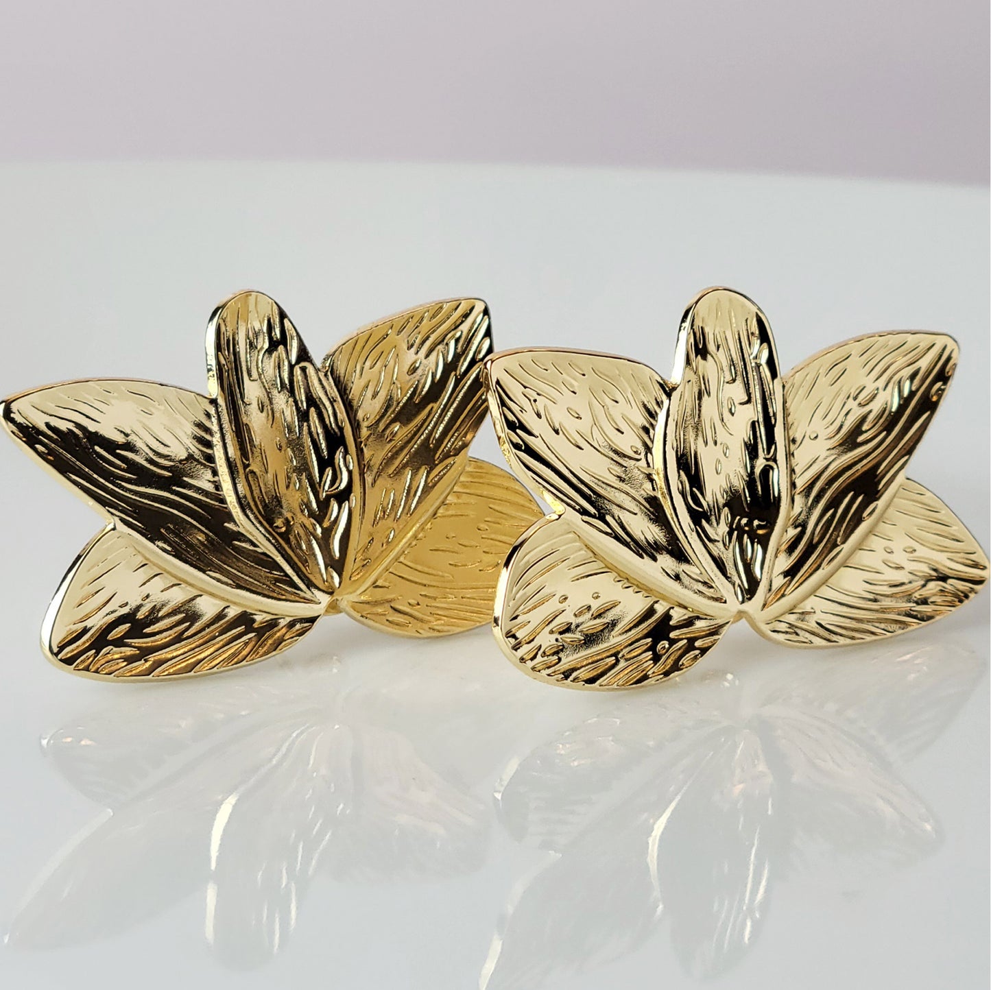 Crafted with the highest quality hypoallergenic stainless steel, these Gold Flower Leaf Stud Earrings are both sustainable and low maintenance. Say goodbye to tarnishing and hello to everyday lightweight comfort. A stylish addition to any outfit.