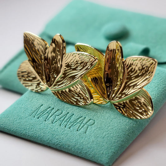 Crafted with the highest quality hypoallergenic stainless steel, these Gold Flower Leaf Stud Earrings are both sustainable and low maintenance. Say goodbye to tarnishing and hello to everyday lightweight comfort. A stylish addition to any outfit.