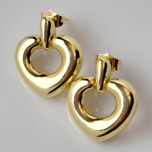 Introducing our Gold Heart Dangle Earrings, crafted from hypoallergenic, tarnish-proof stainless steel. These earrings are not only sustainable, but also low maintenance and lightweight for comfortable wear. Upgrade your style with the highest quality and durability.