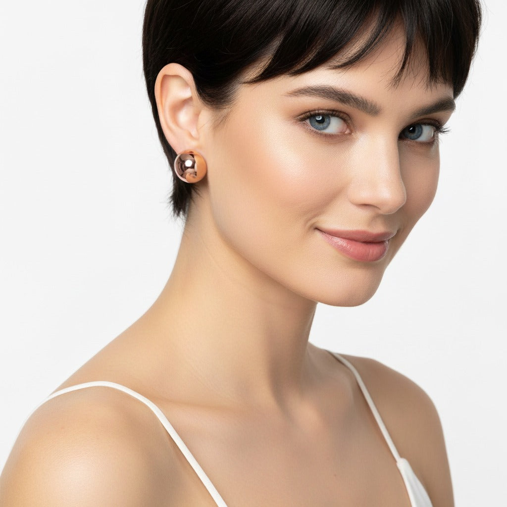 Woman wearing a gold earring on a plain background