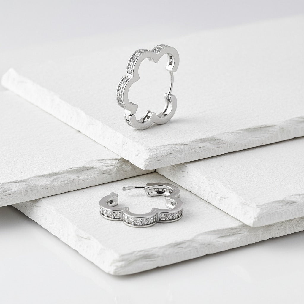 Silver ring and hoop earrings on a white surface