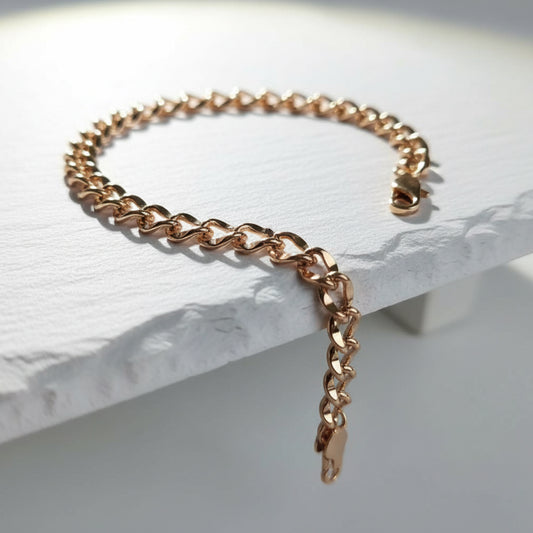 Rose gold chain bracelet on a light stone surface