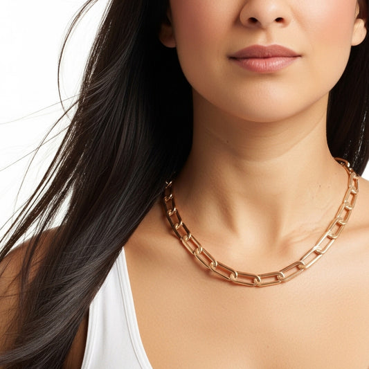 Close-up of a woman wearing a rose gold chain necklace on a white background