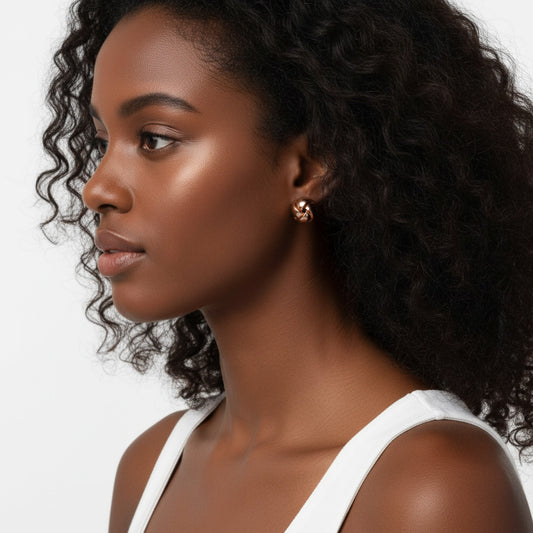 Woman with curly hair wearing a white top against a neutral background