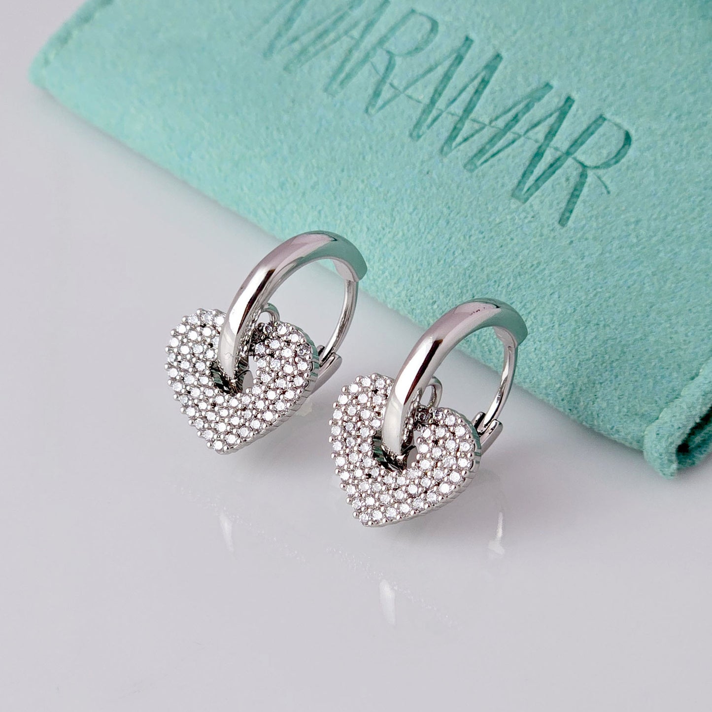 Crafted from low maintenance and hypoallergenic stainless steel, these Small Silver Sparkle Hearts Hoop Earrings boast a tarnish-proof design that is both sustainable and lightweight. Enjoy high-quality, luxurious style without any worries of skin irritation.