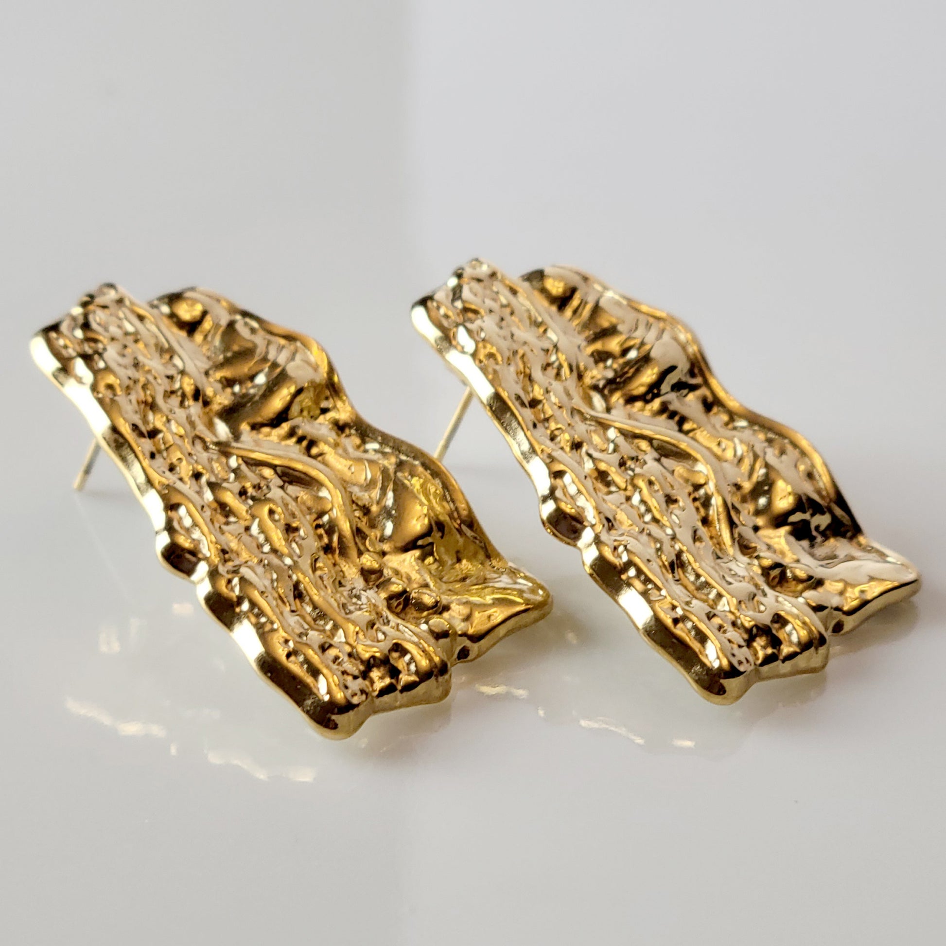 These Gold Chunky Rectangular Dangle Earrings are expertly crafted with hypoallergenic stainless steel to provide a sustainable, low maintenance option for your jewelry collection. Their tarnish-proof design ensures long-lasting wear, while their lightweight construction offers comfort for all-day wear. Elevate your style with these elegant and versatile earrings.