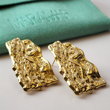 These Gold Chunky Rectangular Dangle Earrings are expertly crafted with hypoallergenic stainless steel to provide a sustainable, low maintenance option for your jewelry collection. Their tarnish-proof design ensures long-lasting wear, while their lightweight construction offers comfort for all-day wear. Elevate your style with these elegant and versatile earrings.