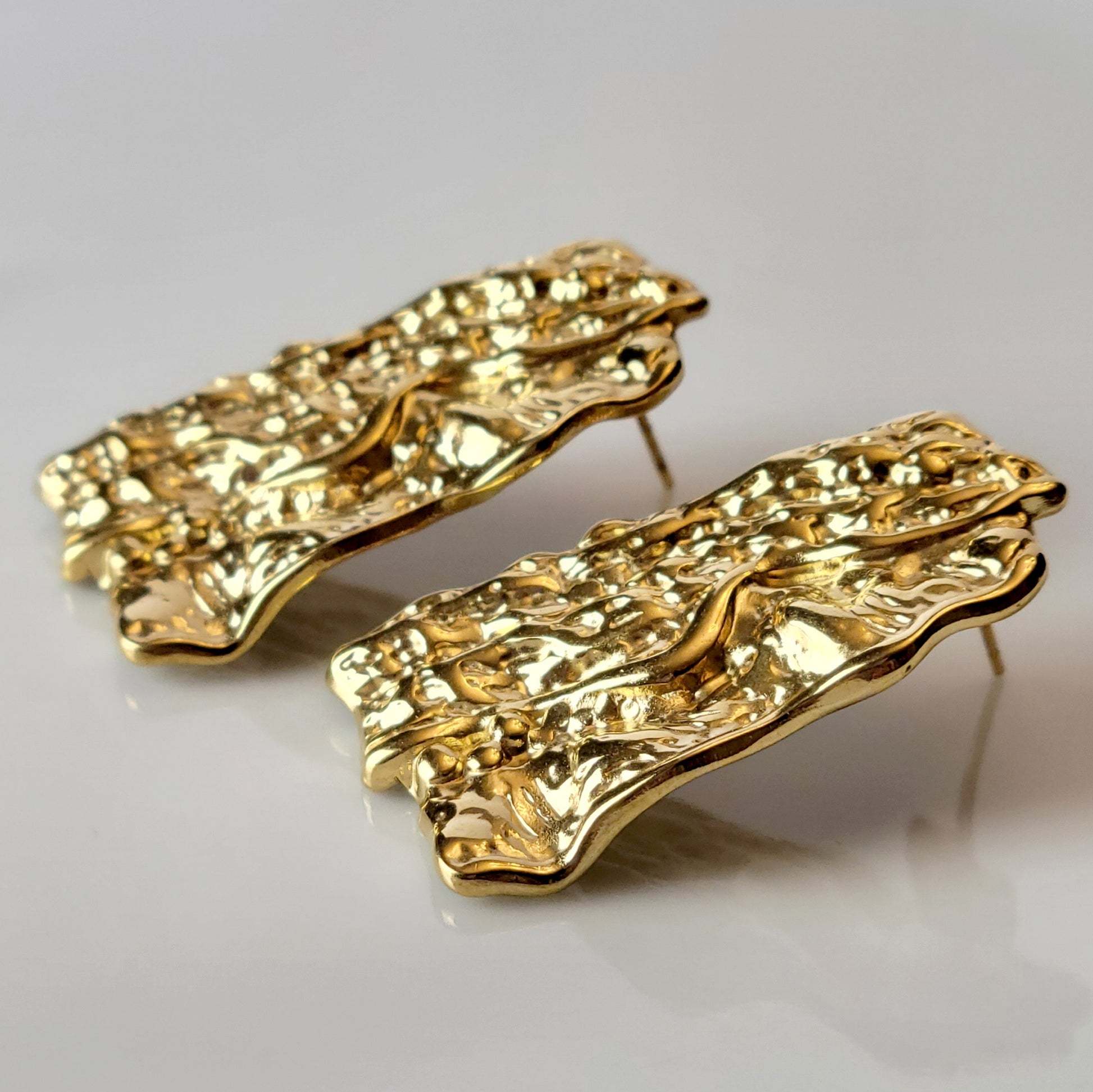 These Gold Chunky Rectangular Dangle Earrings are expertly crafted with hypoallergenic stainless steel to provide a sustainable, low maintenance option for your jewelry collection. Their tarnish-proof design ensures long-lasting wear, while their lightweight construction offers comfort for all-day wear. Elevate your style with these elegant and versatile earrings.