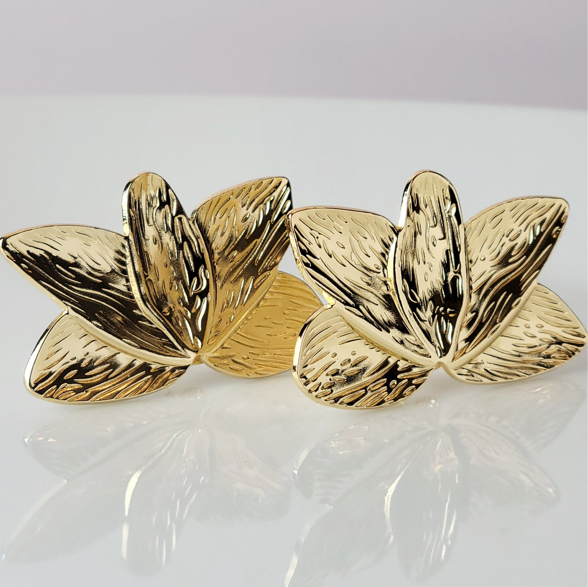 Crafted with the highest quality hypoallergenic stainless steel, these Gold Flower Leaf Stud Earrings are both sustainable and low maintenance. Say goodbye to tarnishing and hello to everyday lightweight comfort. A stylish addition to any outfit.