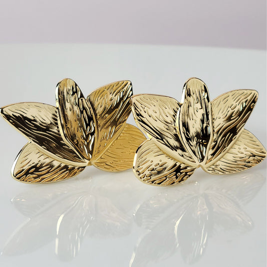 Crafted with the highest quality hypoallergenic stainless steel, these Gold Flower Leaf Stud Earrings are both sustainable and low maintenance. Say goodbye to tarnishing and hello to everyday lightweight comfort. A stylish addition to any outfit.