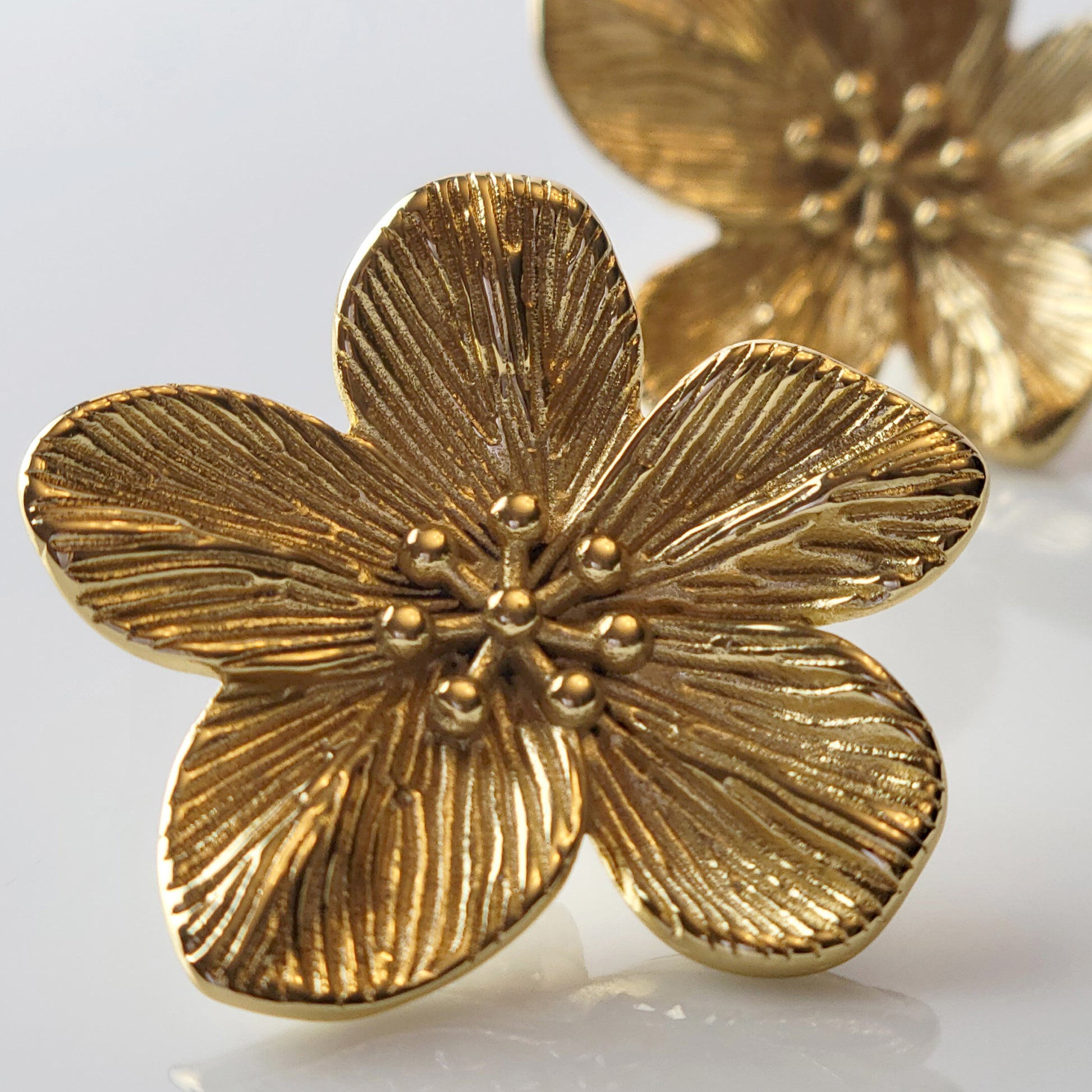 Expertly crafted from hypoallergenic, tarnish-proof stainless steel, these Gold Flower Stud Earrings offer both quality and sustainability. With a low maintenance design and lightweight feel, these earrings are the perfect addition to any jewelry collection.