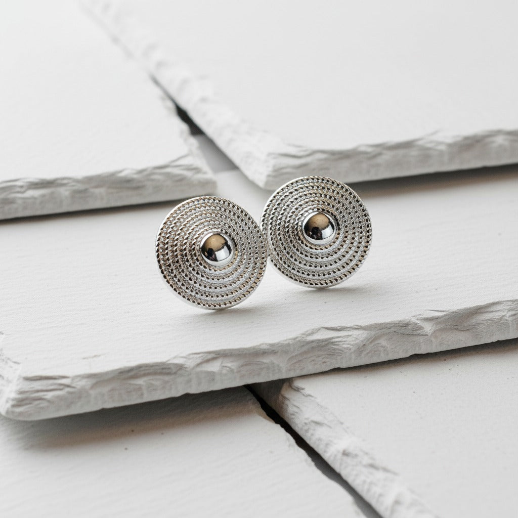 Pair of silver earrings on a light wooden surface