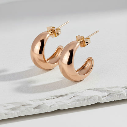 Rose gold hoop earrings on a marble surface