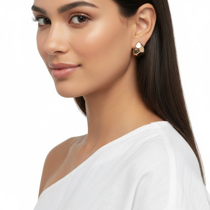 Woman wearing gold earrings on a white background