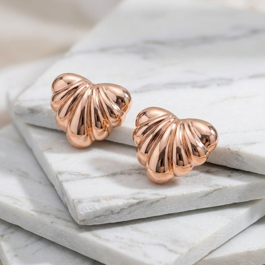Rose gold shell-shaped earrings on a marble surface Medium Rose Gold Maré Heart Stud Earrings premium stainless steel hypoallergenic, waterproof, tarnish-proof, and lightweight