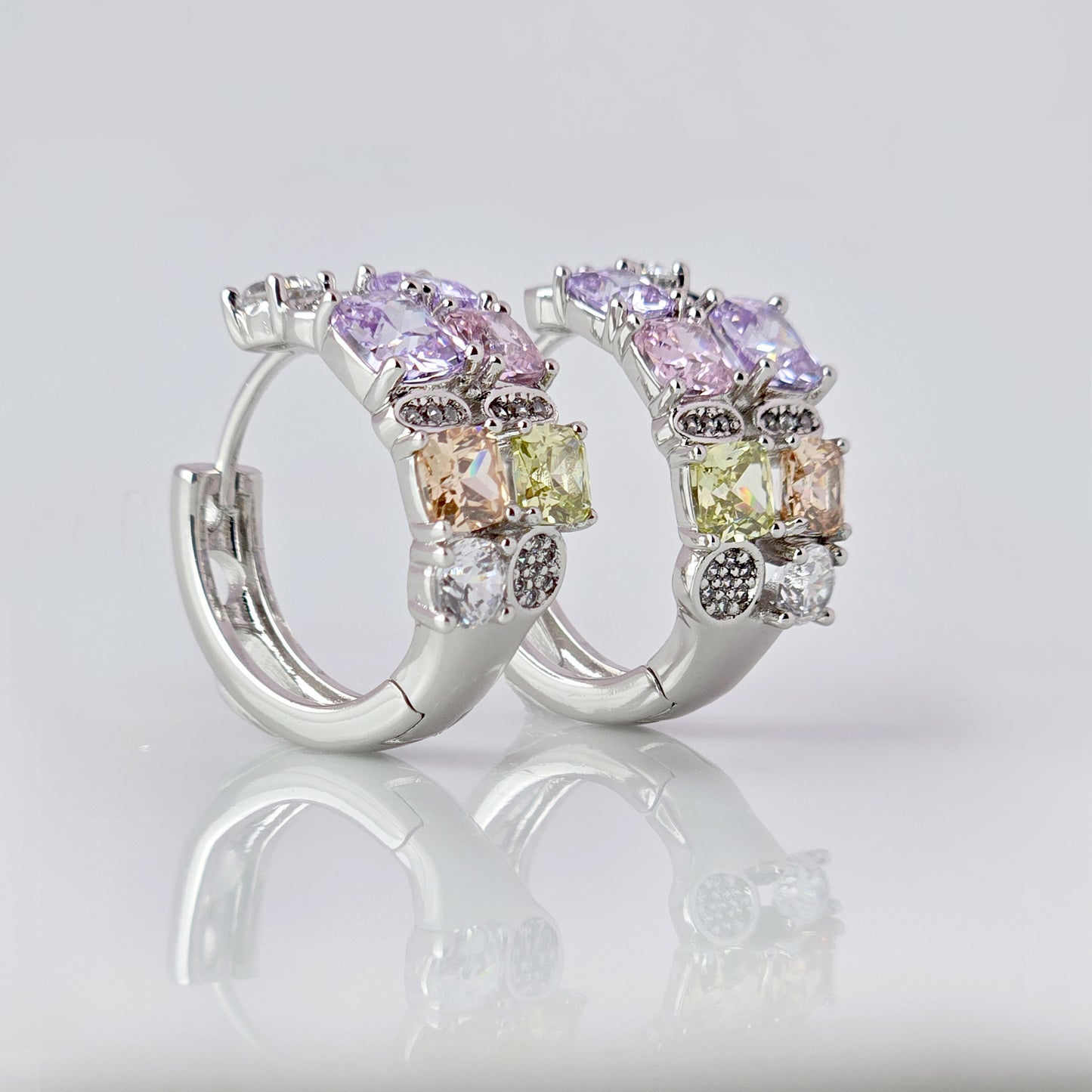 These elegant huggie earrings feature medium-sized silver pink and purple stones. Made from hypoallergenic, tarnish-proof, and sustainable stainless steel, they are low maintenance and lightweight for comfortable all-day wear.