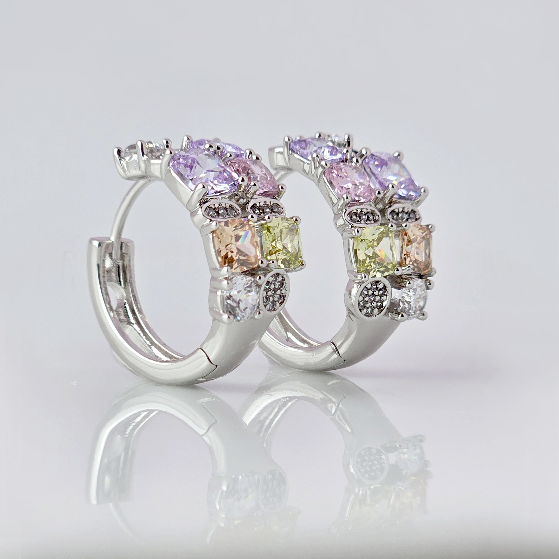These elegant huggie earrings feature medium-sized silver pink and purple stones. Made from hypoallergenic, tarnish-proof, and sustainable stainless steel, they are low maintenance and lightweight for comfortable all-day wear.