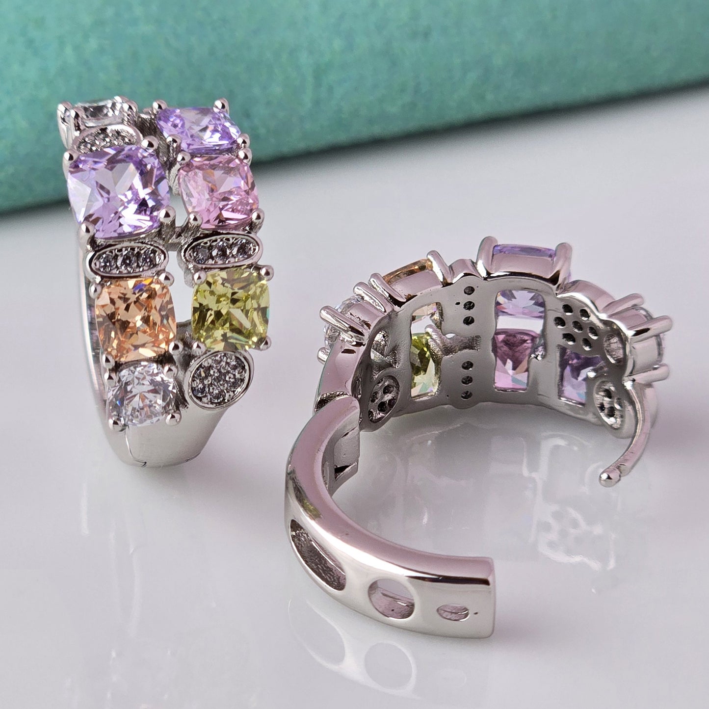 These elegant huggie earrings feature medium-sized silver pink and purple stones. Made from hypoallergenic, tarnish-proof, and sustainable stainless steel, they are low maintenance and lightweight for comfortable all-day wear.