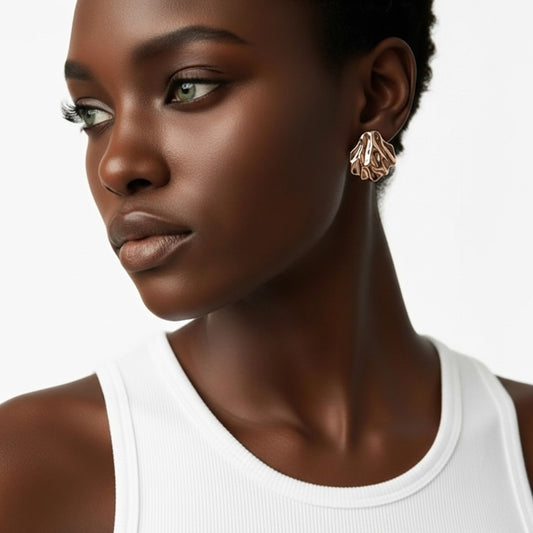 Close-up of a woman wearing gold earrings with a white background