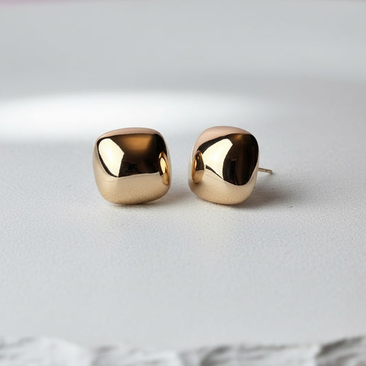 Pair of gold earrings on a light gray background