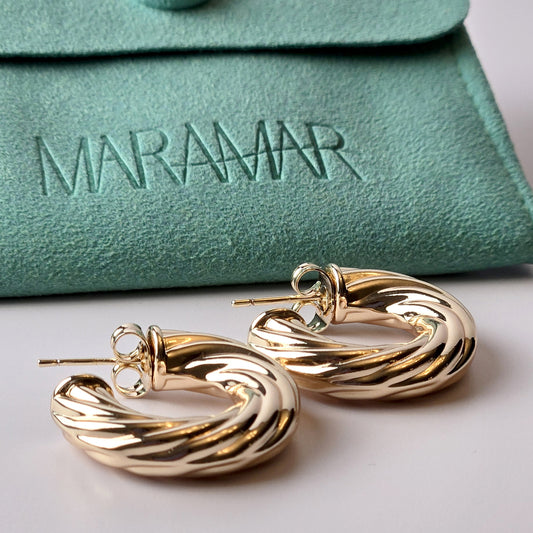 These Rose Gold Twisted Hoop Earrings are expertly crafted using hypoallergenic, water-resistant, and sweat-resistant stainless steel, ensuring a durable and sustainable product. With a tarnish-proof finish, they require low maintenance and are lightweight for comfortable wear. Elevate your style with these high-quality earrings.