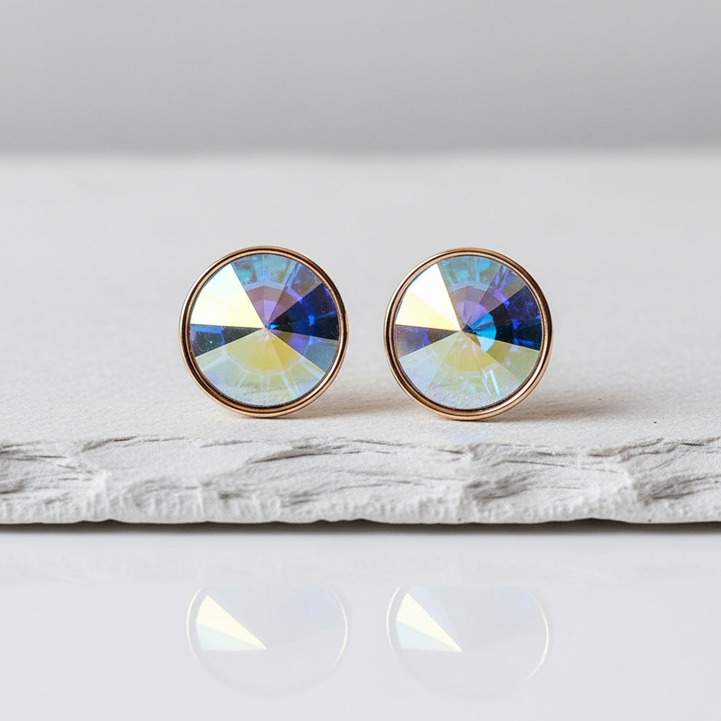 Round earrings with multicolored gemstones on a white surface