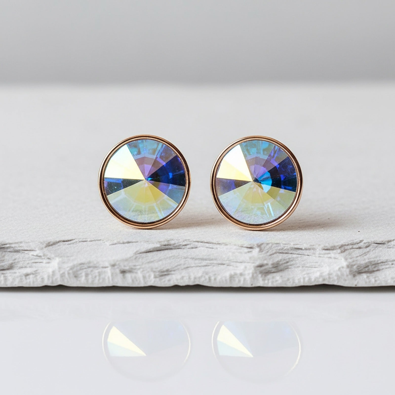 Round earrings with multicolored gemstones on a white surface