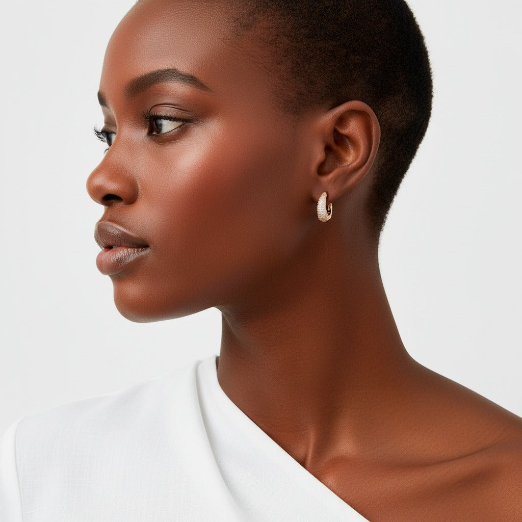 Woman wearing gold hoop earrings on a white background