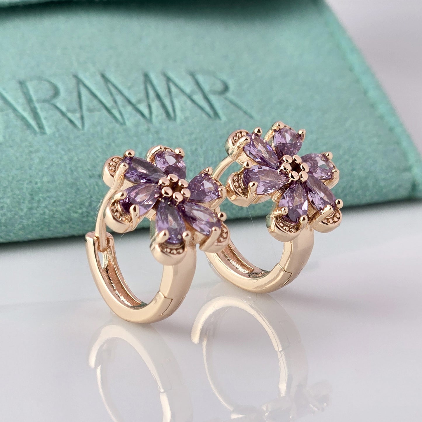 Crafted with the highest quality hypoallergenic stainless steel, these Small Rose Gold Purple Flower Huggie Earrings are both sustainable and lightweight. With a tarnish-proof design and low maintenance requirements, these earrings are a durable and stylish addition to any accessory collection.