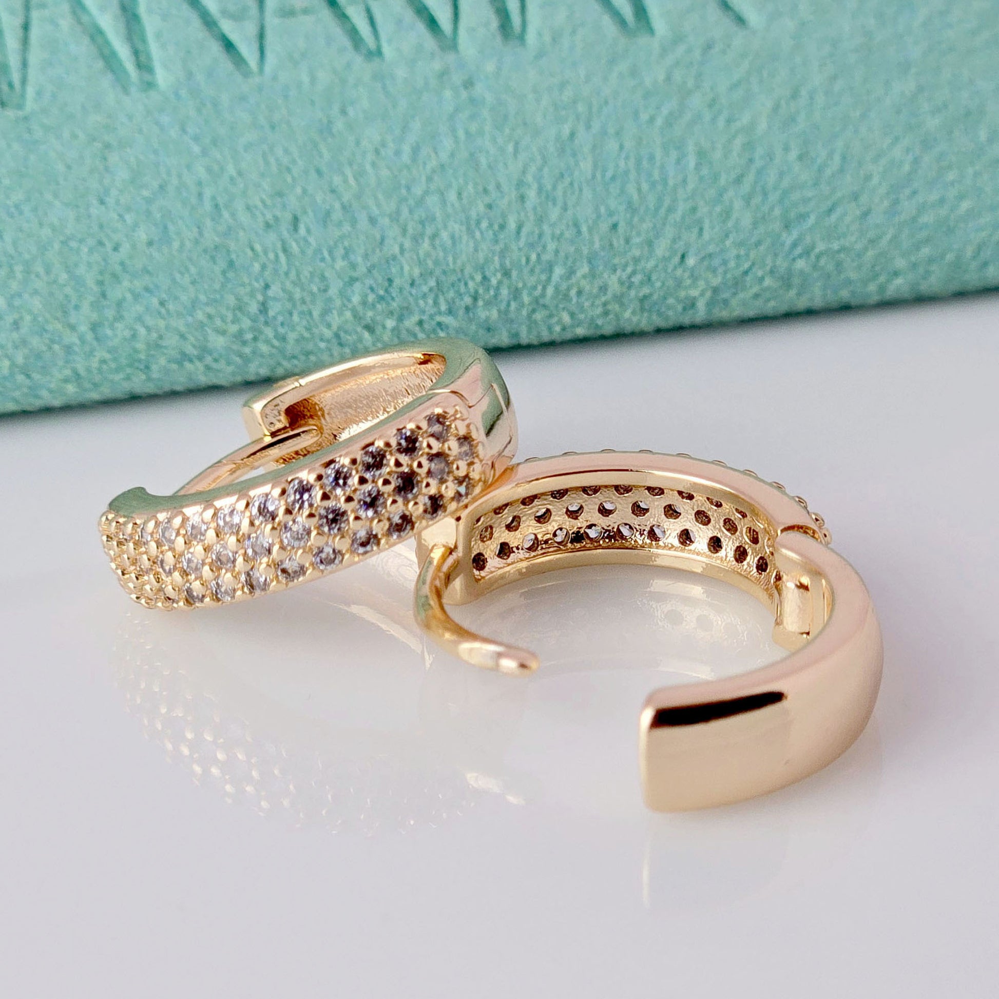 Expertly crafted from hypoallergenic, tarnish-proof stainless steel, these Small Rose Gold Sparkle Huggie Earrings offer both style and sustainability. With low maintenance and a lightweight design, they are perfect for everyday wear. Elevate your look with these high-quality, durable earrings.