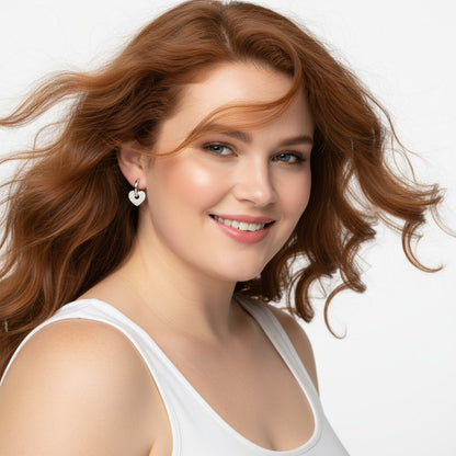 Woman with wavy brown hair wearing a white tank top against a light background
