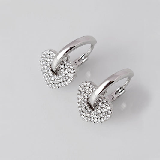 Crafted from low maintenance and hypoallergenic stainless steel, these Small Silver Sparkle Hearts Hoop Earrings boast a tarnish-proof design that is both sustainable and lightweight. Enjoy high-quality, luxurious style without any worries of skin irritation.