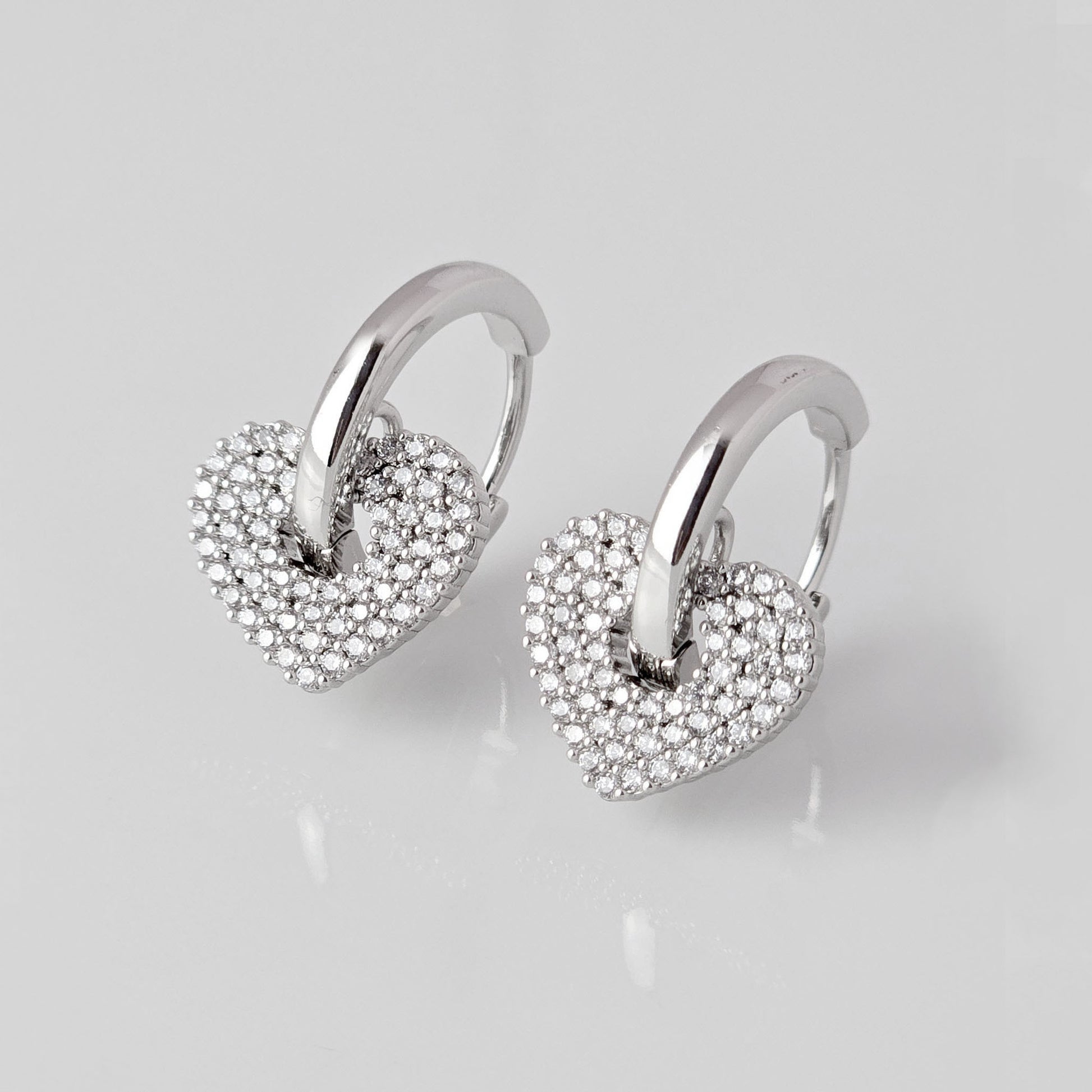 Crafted from low maintenance and hypoallergenic stainless steel, these Small Silver Sparkle Hearts Hoop Earrings boast a tarnish-proof design that is both sustainable and lightweight. Enjoy high-quality, luxurious style without any worries of skin irritation.