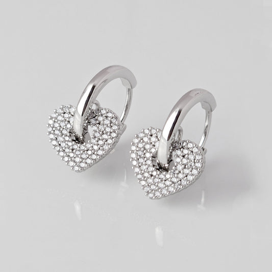 Crafted from low maintenance and hypoallergenic stainless steel, these Small Silver Sparkle Hearts Hoop Earrings boast a tarnish-proof design that is both sustainable and lightweight. Enjoy high-quality, luxurious style without any worries of skin irritation.