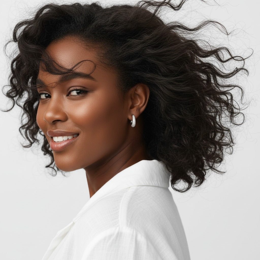 Woman with styled hair wearing a white shirt against a light background