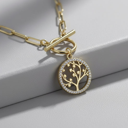 Gold necklace with the Golden tree of life charm on a light gray background