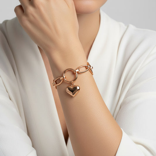 Rose gold bracelet with a heart charm on a white background